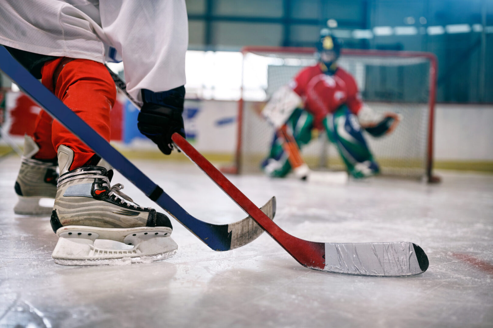 ice hockey player in action kicking with stick on goal