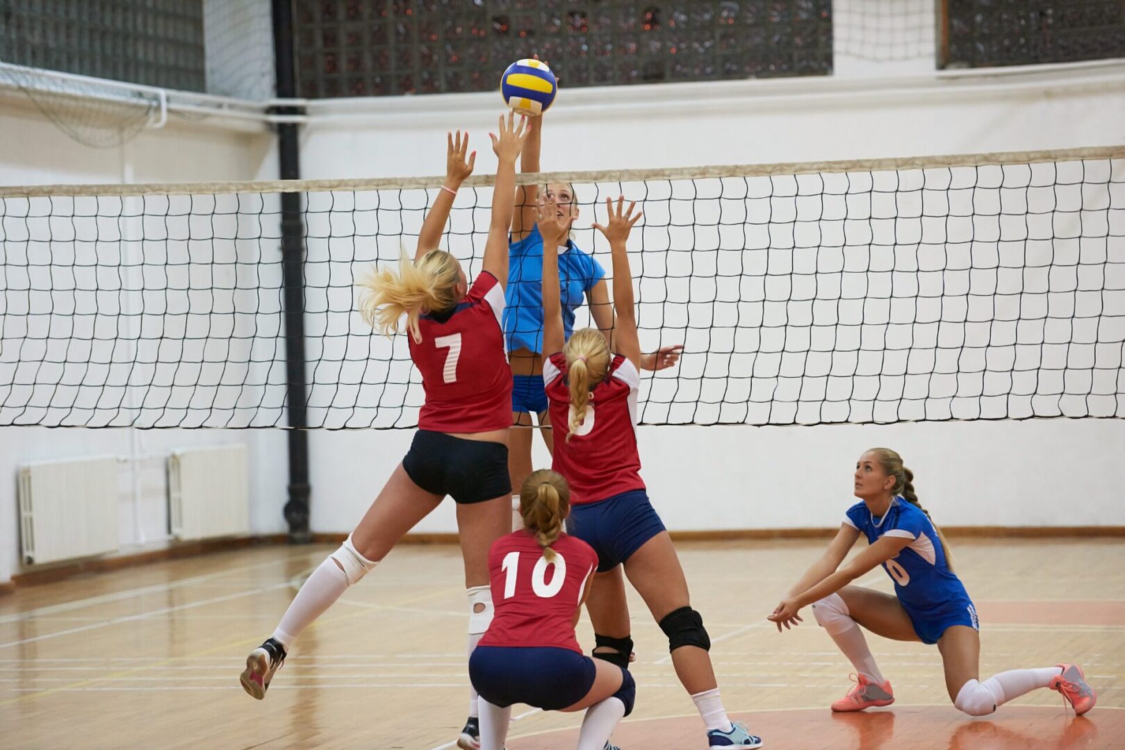 volleyball game sport with group of young beautiful girls indoor in sport arena school gym